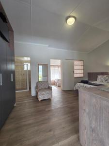 a large room with a bed and a chair at Mountain Shadows Hotel in Barkly East
