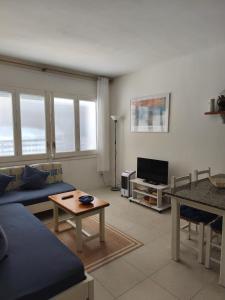 a living room with a blue couch and a tv at Apartamento Blanes Vela Port in Blanes