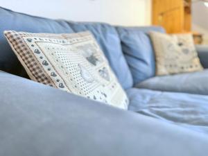 a blue couch with a pillow on it at Sonnenhof Seeg 01 in Seeg +28 photos