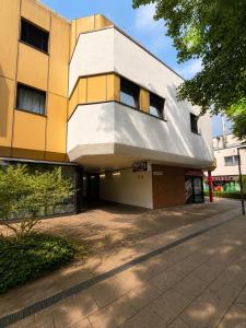 ein gelb-graues Gebäude mit einer Einfahrt in der Unterkunft Vintage HOTEL S-Weilimdorf in Stuttgart-Weilimdorf
