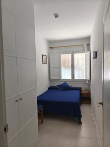 a bedroom with a blue bed and a window at Apartamento Blanes Vela Port in Blanes +9 photos