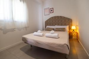 a bedroom with a bed with two towels on it at Villa Clio by Concept Flats in Novaliches +50 photos