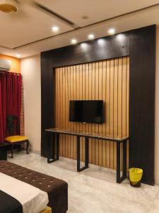 a room with a flat screen tv on a wall at Palmtree Hotel in Lahore