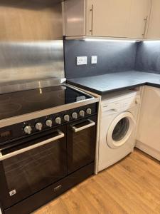 a kitchen with a stove and a washing machine at Central 2 bed large apt M1 area in Manchester +11 photos