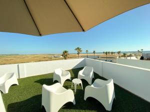 a group of white chairs sitting on a roof at 1 linea de playa - Apartamentos - Beach & River - Conil in Conil de la Frontera
