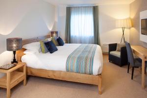 a hotel room with a bed and a desk and a chair at St Moritz Hotel and Cowshed Spa in Polzeath