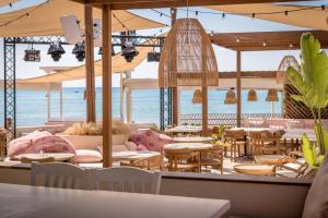 a restaurant with tables and chairs and the ocean at CP Seafront Suites in Laganas