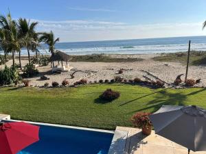 a view of the beach from a resort with an umbrella at Casa Fuente Ocean Villa in Santa María Colotepec