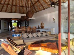 a living room with a couch and a table and chairs at Casa Fuente Ocean Villa in Santa María Colotepec