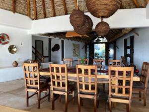 a dining room with a wooden table and chairs at Casa Fuente Ocean Villa in Santa María Colotepec +89 photos