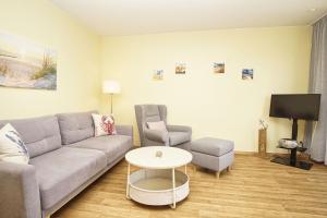 a living room with a couch and a table and a tv at Haus Rügen Ferienwohnung 08 mit Sauna- und Schwimmbadnutzung im AHOI Sellin in Göhren