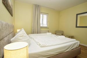 a bedroom with two beds and a window at Haus Rügen Ferienwohnung 08 mit Sauna- und Schwimmbadnutzung im AHOI Sellin in Göhren +18 photos