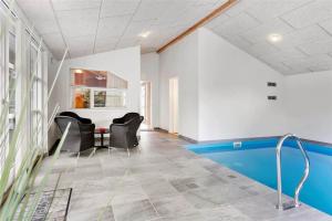 a room with a pool and two chairs and a table at M12018-Vaeggerlose-Baeverstien-11 in Bøtø By
