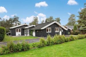 a black and white house with a yard at M12018-Vaeggerlose-Baeverstien-11 in Bøtø By