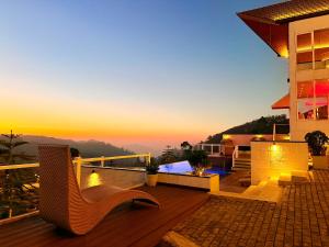 a house with a deck with a sunset in the background at Hilldale Retreat in Nuwara Eliya