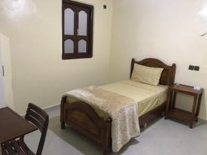 a bedroom with a bed and a table and a window at Tiznit afolki in Tiznit