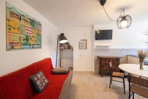 a living room with a red couch and a table at Villa Clio by Concept Flats in Novaliches