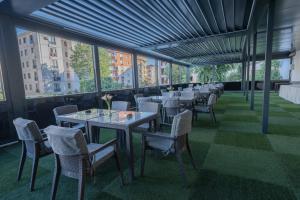 a row of tables and chairs in a room with windows at Tryp By Wyndham Istanbul Sancaktepe in Istanbul