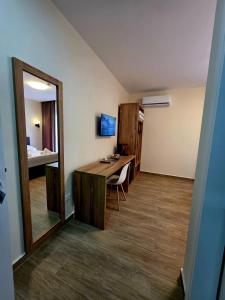 a room with a desk with a mirror and a bedroom at Voyyo Skyline in Durrës