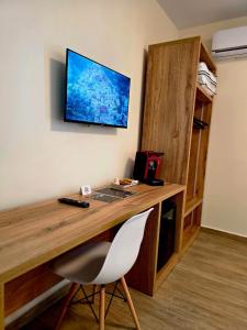 a desk with a chair and a television on a wall at Voyyo Skyline in Durrës