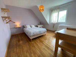a bedroom with a bed and a couch in a room at Maison avec sauna en Presqu'île de Crozon pour 6 personnes in Crozon