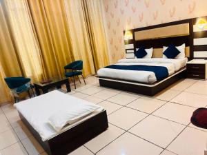 a hotel room with a bed and a table and chairs at Crystal Park Hotel And Restaurant in Lalru