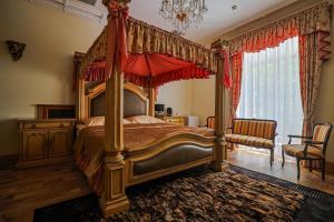 a bedroom with a canopy bed with a red umbrella at Zamek Dubiecko in Dubiecko