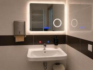 a bathroom with a sink and a mirror at NEU! Fly & Stay Residence Frankfurt Airport Kelsterbach in Kelsterbach