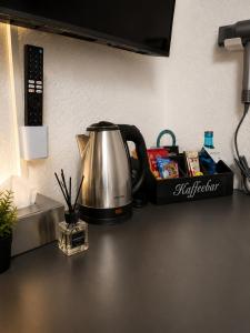 a tea kettle sitting on top of a counter at NEU! Fly & Stay Residence Frankfurt Airport Kelsterbach in Kelsterbach +16 photos