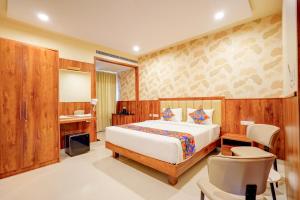 a bedroom with a bed and a desk and a mirror at FabHotel Golden Stay I in Bangalore