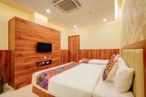 a bedroom with a bed and a flat screen tv at FabHotel Golden Stay I in Bangalore