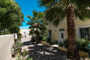 a house with palm trees in front of it at Guesthouse Villa Maggie by Adex travel in Zadar