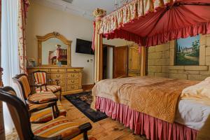 a bedroom with a large canopy bed and a chair at Zamek Dubiecko in Dubiecko