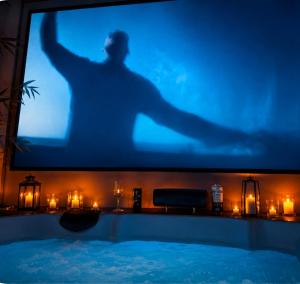 a television with a silhouette of a man on a screen at Aconchego Valença & Spa in Nova Friburgo