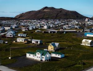 an aerial view of a small village with a mountain in the background at Guesthouse Grund in Grindavík