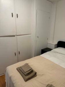 a bedroom with a bed with white cabinets and a towel at Petit chambre tous conforts in Charleroi