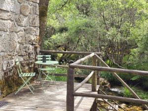 a wooden deck with a table and chairs on it at Moinhos do Poço Verde in Castro Laboreiro
