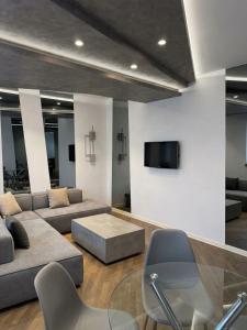 a living room with a couch and a tv on a wall at Apartments Belgrade in Belgrade