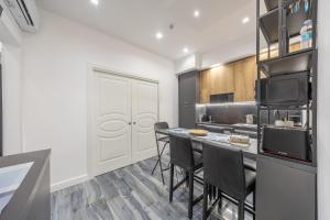 a kitchen with a counter with chairs and a table at Anzio Central Apartments in Anzio