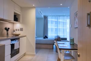 a kitchen and living room with a bed and a table at New! Luxury Central Complex with Pool Access & Sleeps 4 Ppl in Gibraltar