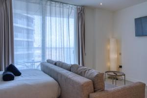 a living room with a couch and a large window at New! Luxury Central Complex with Pool Access & Sleeps 4 Ppl in Gibraltar +30 photos