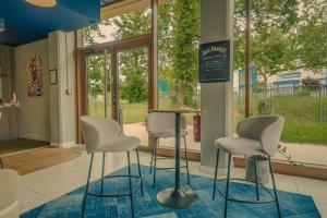 a waiting room with three chairs and a table at Hôtel AKENA Serris - Val d'Europe in Serris