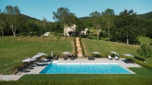 an overhead view of a swimming pool with chairs and umbrellas at Tenuta Valdea in Firenzuola
