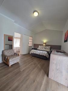 a large room with two beds and a chair at Mountain Shadows Hotel in Barkly East