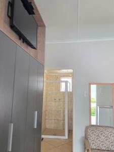 a living room with a television and a bathroom at Mountain Shadows Hotel in Barkly East
