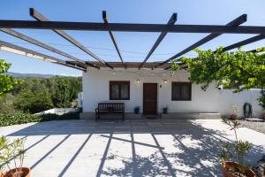 a patio with a bench under a pergola at Villa Clio by Concept Flats in Novaliches