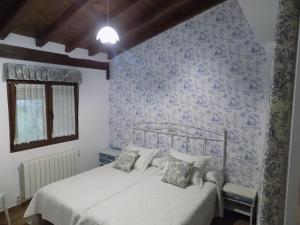 um quarto com 2 camas e papel de parede azul em El Capricho em Sotoserrano