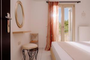 a bedroom with a bed and a mirror and a window at Villa Guesto with Private Pool by MindYourVilla in Anafonítria +43 photos