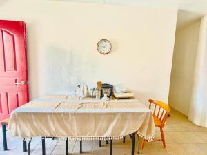 a table in a room with a clock on the wall at Maru Vibe Guesthouse V2 in San Juan