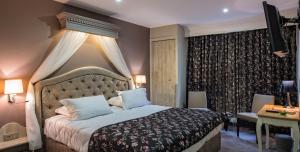 ein Schlafzimmer mit einem großen Bett mit Baldachin in der Unterkunft La Terrasse in Douai